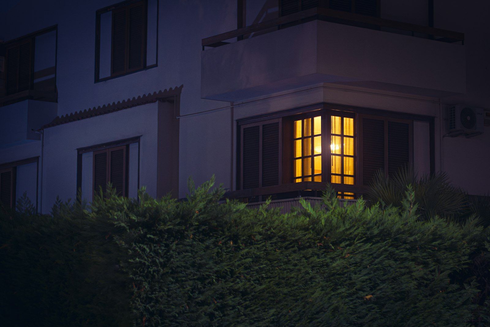 A building with a lit up window at night

